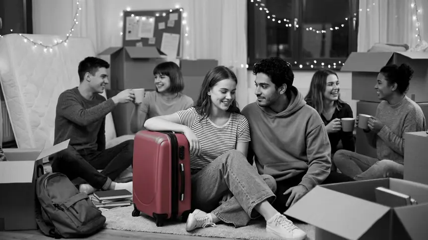 L’última nit abans de deixar la residència a l’estiu, un grup d’amics universitaris d’uns dinou o vint anys seu a terra d’una habitació d’estudiant mig empaquetada, entre caixes de cartró senzilles i llumetes, rient i passant-se begudes; un noi amb una dessuadora grisa llisa i una noia amb una samarreta de ratlles i texans amples seuen espatlla amb espatlla al costat de la maleta rosa intens d’ella, compartint una mirada tímida i esperançada.